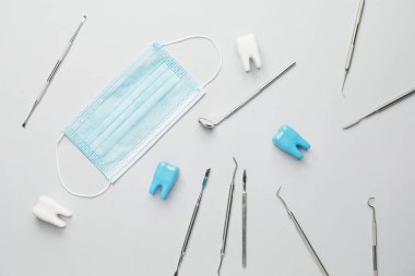 Dişçi aletleri, plastik dişler ve açık arkaplanda maskeler