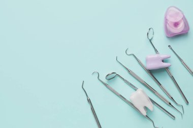 Renkli arka planda dişçi aletleri ve plastik dişler