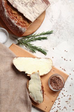 Tereyağlı taze ekmek dilimleri, keten tohumları ve arka planda biberiye.