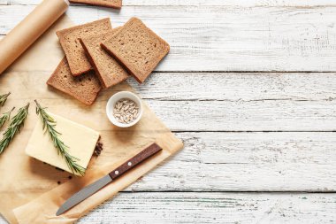 Hafif ahşap zemin üzerinde taze tereyağı ve ekmek içeren kompozisyon