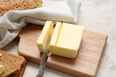 Hafif arka planda taze tereyağı olan ahşap tahta, yakın plan.