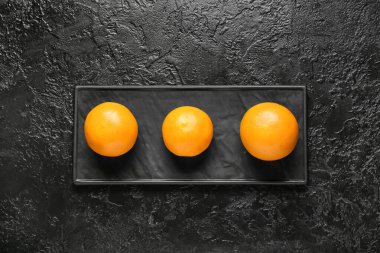 Koyu arkaplanda olgun greyfurtlar olan tahta