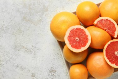 Açık arkaplanda olgun greyfurtlarla dolu bir kutu