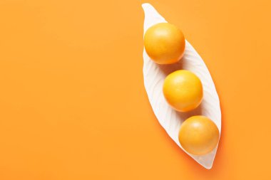 Renkli arkaplanda olgun greyfurtlu tabak