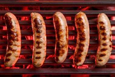 Izgarada pişen lezzetli sosisler.