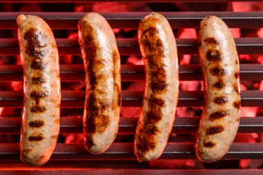 Izgarada pişen lezzetli sosisler.