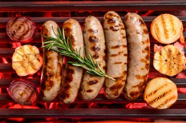 Lezzetli sosisler ve ızgarada pişen sebzeler.