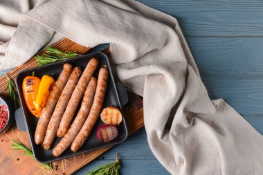 Ahşap arka planda lezzetli ızgara sosisli fırın.