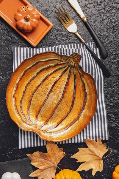 Karanlık arka planda Şükran Günü kutlaması için şık bir masa.