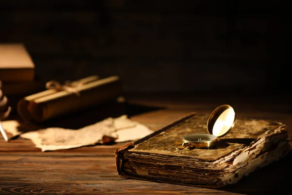 Masanın Üzerinde Pusula Olan Eski Kitap Karanlık Arka Plana Karşı — Stok fotoğraf