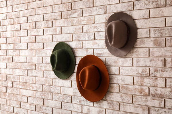 Стильные шляпы на светлом кирпичном фоне