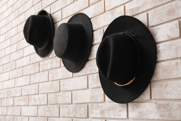 Стильные шляпы на светлом кирпичном фоне