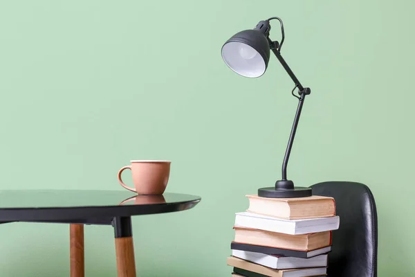 Stol Med Böcker Och Lampa Nära Ljusvägg — Stockfoto