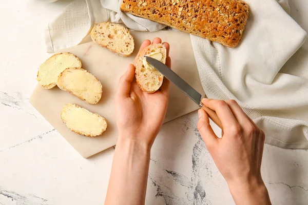 Vrouw Die Boter Strooit Sneetjes Brood Een Lichte Achtergrond — Stockfoto