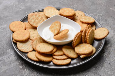 Krakerli tabak ve grunge arkaplanda sos