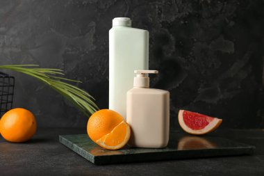 Duş jeli şişeleri ve arka planda meyveler.