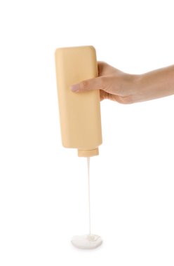 Beyaz arka plana duş jeli döken kadın