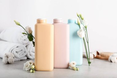 Açık arkaplanda duş jelleri ve çiçekleri olan kompozisyon