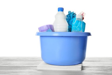 Tahta masadaki temizlik malzemeleri beyaz arka plana karşıydı.