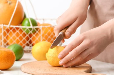 Açık arkaplanda limon kesen kadın