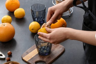 Koyu arkaplanda limon sıkan kadın