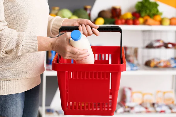 Woman buying milk in supermarket