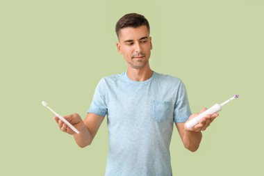 Arka planda diş fırçası olan genç bir adam.