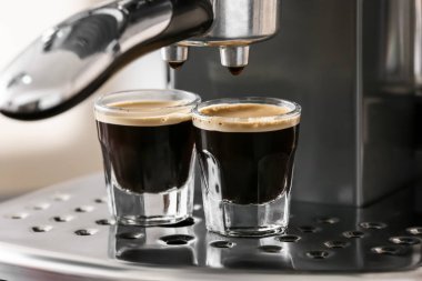 Kafede bir fincan sıcak espresso ile modern kahve makinesi.