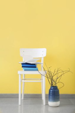 Renk arkaplanı üzerine kitap yığını olan sandalye
