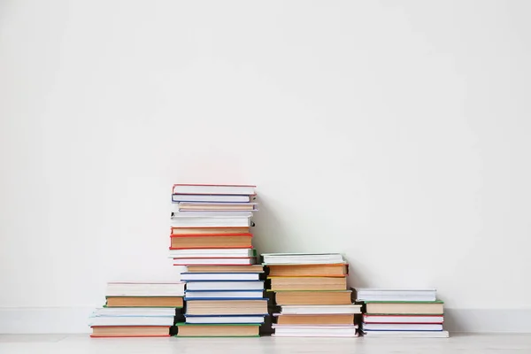 Stack of books near light wall in room