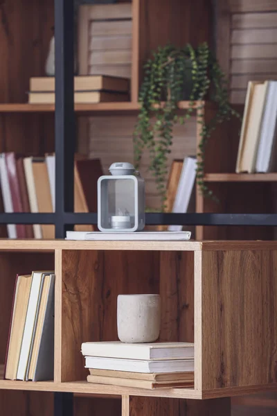 Shelf unit with stack of books and decor, closeup