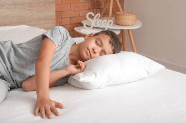 Küçük çocuğun rahat bir yatakta uyuduğu bir sabah.