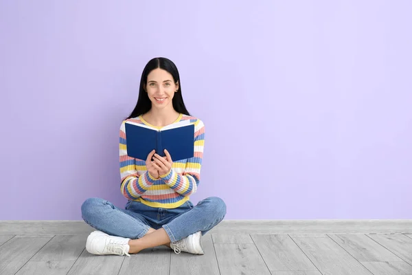 Belle Jeune Femme Avec Livre Assis Près Mur Couleur — Photo