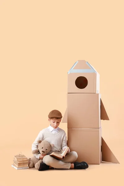 Cute Little Boy Books Toy Cardboard Rocket Color Background — Stock Photo, Image