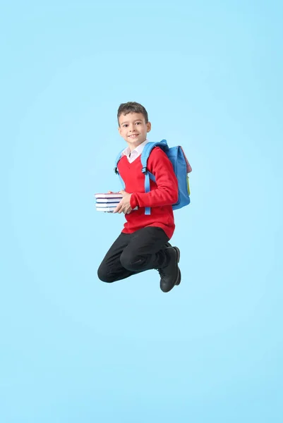 跳着的小男孩 带着彩色背景的书 — 图库照片