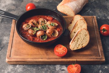 Arkaplanda lezzetli salyangozlar olan kızartma tavası