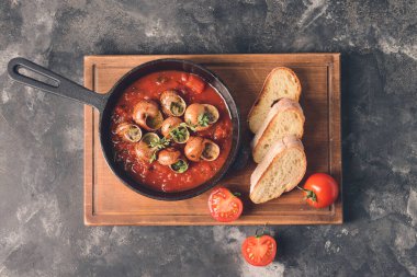 Arkaplanda lezzetli salyangozlar olan kızartma tavası