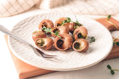 Hafif arka planda lezzetli salyangozlu tabak