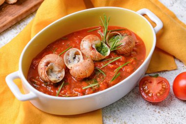 Hafif arka planda lezzetli salyangozlu fırın yemeği.