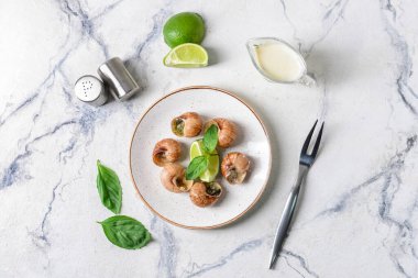 Hafif arka planda lezzetli salyangozlu tabak