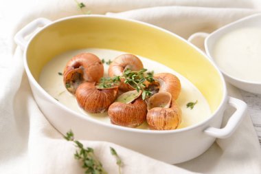 Hafif arka planda lezzetli salyangozlu fırın yemeği.