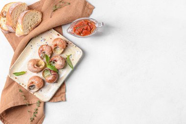 Hafif arka planda lezzetli salyangozlu tabak