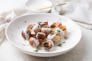 Hafif arka planda lezzetli salyangozlu tabak