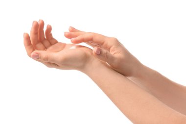 Genç bir kadın beyaz arka plana krem sürüyor.