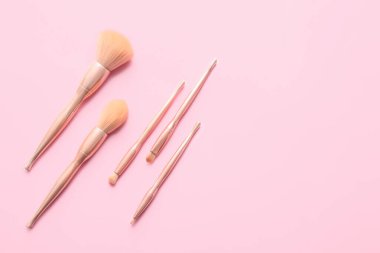 Renkli arkaplanda şık makyaj fırçaları