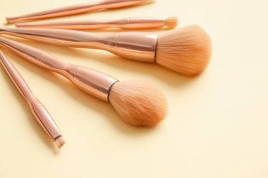 Renkli arkaplanda şık makyaj fırçaları