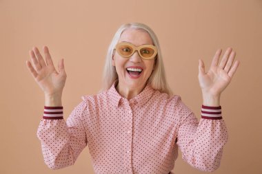 Renkli güneş gözlüklü güzel olgun bir kadın.