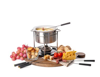 Peynir fondü ve beyaz arka planda farklı atıştırmalıklar.