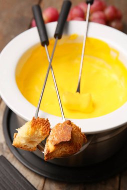 Peynir fondüsüne batırılmış kızarmış ekmek çubukları, yakın plan.