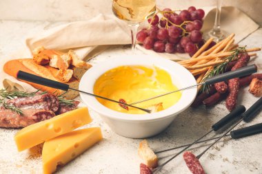 Peynir fondü ve hafif arka planda farklı atıştırmalıklar.